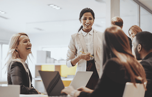 Grupo de colaboradores da AstraZeneca sorrindo em ambiente de trabalho, simbolizando cultura organizacional positiva e compromisso com impacto social e saúde